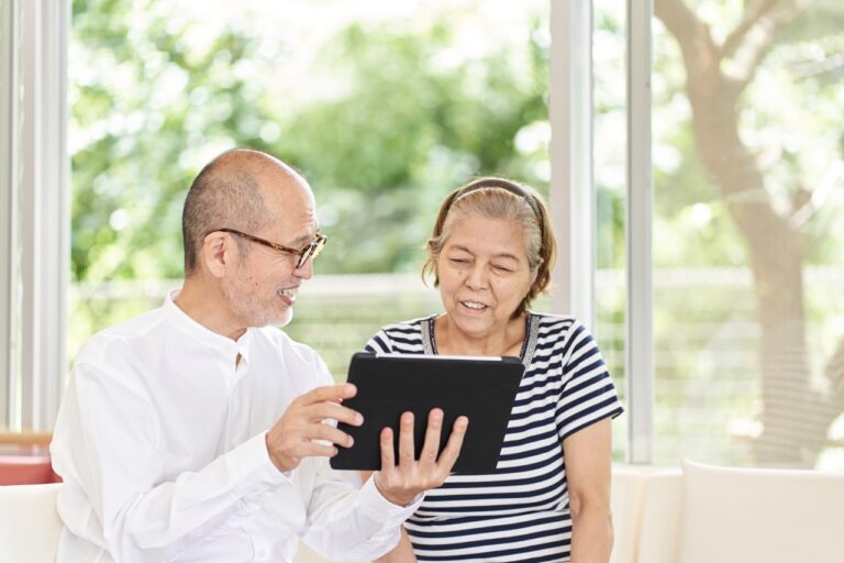 Elderly couple looking at a tablet with a smile